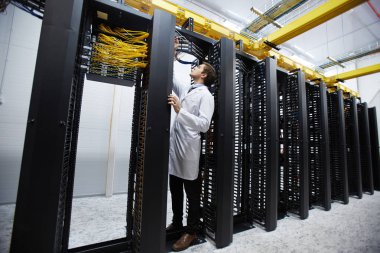 Bitcoin veri depolama sistemi kabloları ile çalışma üniformalı genç teknik Yöneticisi