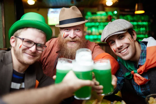 快乐的朋友们在酒吧里喝着泡沫啤酒举杯祝酒 — 图库照片