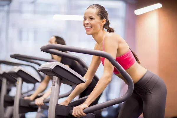 在健身房运动器材的微笑的年轻女子享受锻炼 — 图库照片