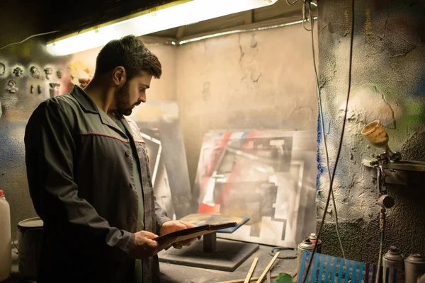 Specialist Uniforme Bedrijf Kladblok Terwijl Kijken Naar Enkele Creatieve Schilderijen — Stockfoto