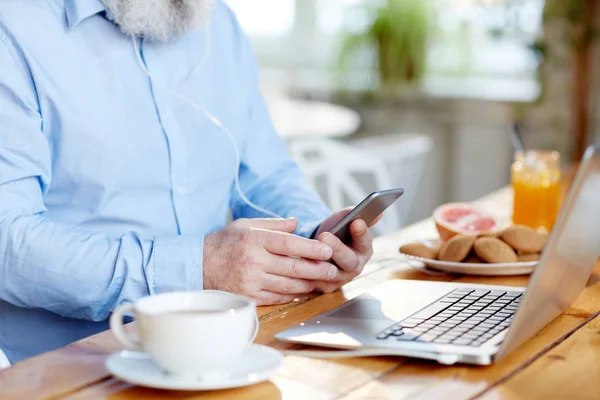 カフェの前のラップトップのテーブルによってスマート フォン テキスト メッセージ携帯電話の年配の男性 — ストック写真