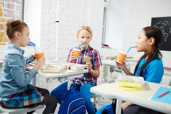 Tres Compañeros Escuela Primaria Comiendo Almuerzo Escritorios Bebiendo Vasos Plástico — Foto de Stock