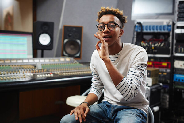 Young producer in casualwear talking to his colleague at break