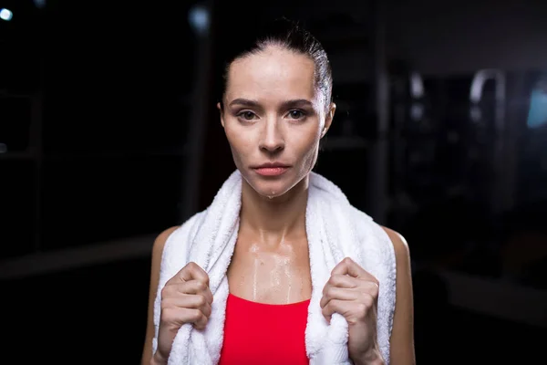 トレーニングの後 カメラを見て白の柔らかいタオルで汗をかくスポーツの女性 — ストック写真