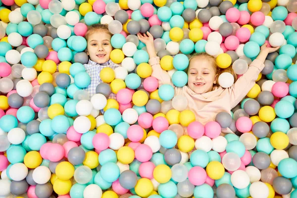 Две Маленькие Веселые Девочки Веселятся Куче Надувных Шариков Разных Цветов — стоковое фото