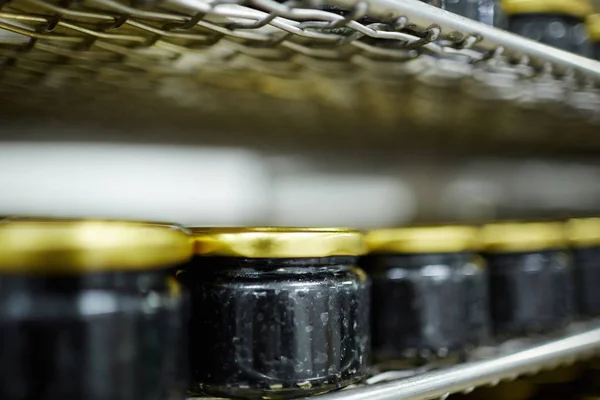 黑色鱼子酱罐头在小罐子站立在一排在超级市场货架上 — 图库照片