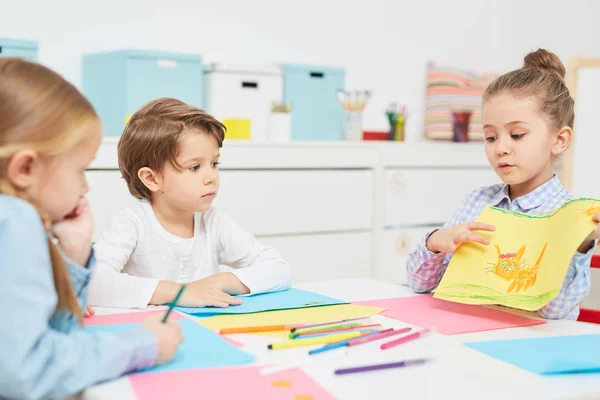 Nette Grundschülerin Zeigt Ihren Freunden Ihr Mit Buntstiften Gezeichnetes Bild — Stockfoto