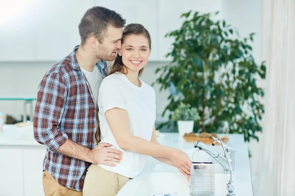 Young Woman Washing Her Hands Kitchen While Amorous Husband Embracing — Stock Photo, Image