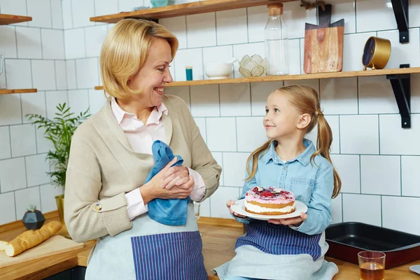 Menina Segurando Deliciosa Sobremesa Caseira Olhando Para Sua Avó Cozinha — Fotografia de Stock