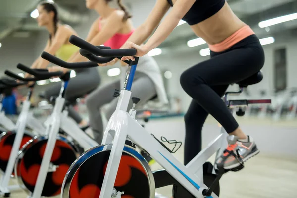 Reihe Sportlicher Mädchen Sitzt Auf Trainingsrädern Sportzentrum Und Macht Übungen — Stockfoto