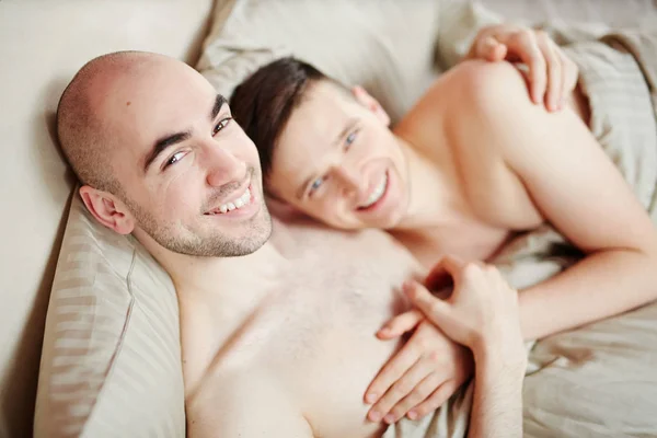 Unga Tillgiven Leende Homosexuella Män Sängen Och Tittar Kameran — Stockfoto