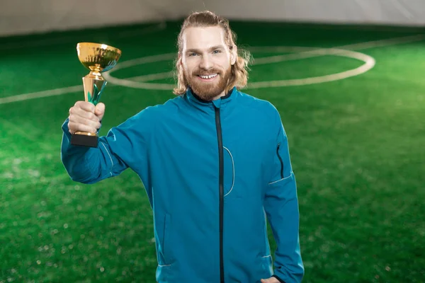Mladý Úspěšný Fotbalista Activewear Drží Cenu Pozadí Zelených Fotbalové Hřiště — Stock fotografie