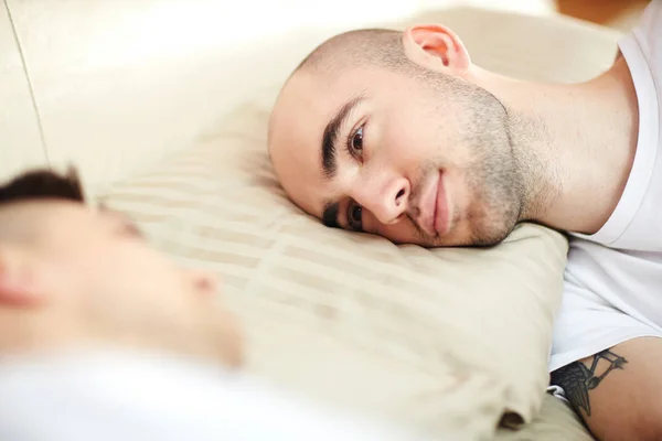 Ung Man Med Huvudet Kudden Sängen Och Tittar Sin Älskare — Stockfoto
