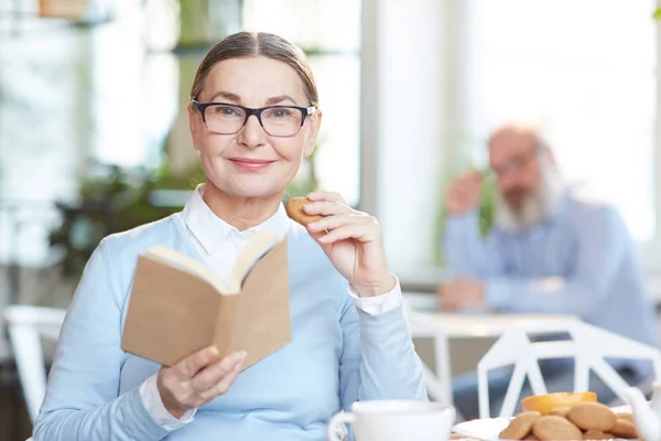 Seniorin Brille Und Freizeitkleidung Sitzt Mit Interessantem Buch Café Und — Stockfoto