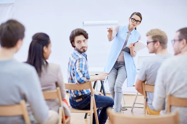 Giovane Insegnante Fiducioso Che Indica Uno Degli Assistenti Mentre Domande — Foto Stock