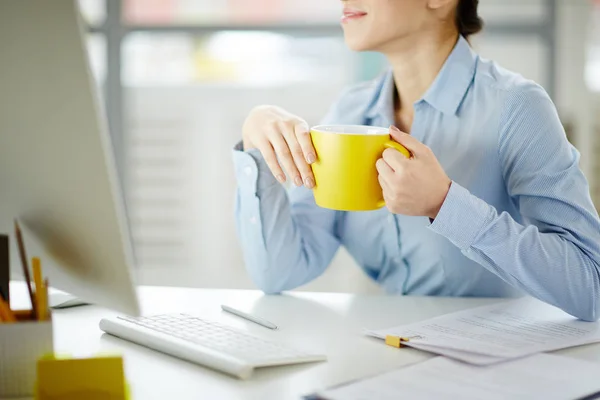 Jovem Mulher Com Caneca Amarela Sentada Mesa Escritório Frente Monitor — Fotografia de Stock