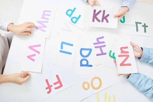 Manos Niños Sosteniendo Tarjetas Papel Con Letras Coloridas Durante Juego —  Fotos de Stock