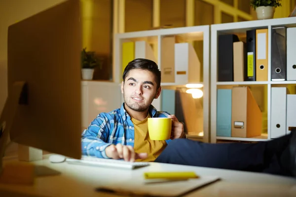 Relaxado Cara Com Xícara Bebida Sentado Frente Computador Tarde Noite — Fotografia de Stock