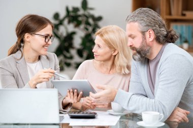 Yetişkin çift, genç başarılı ajanın emekliler için finansal programı sunuşunu dinliyor.