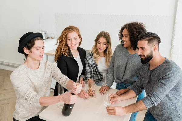 Group Young Casual Friends Flutes Looking One Guys Opening Bottle — Stock Photo, Image