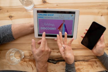 Online mağaza anasayfası tartışması sırasında insanların ellerinin üst görünümü touchpad 'de sayfa düzenleme yaparken