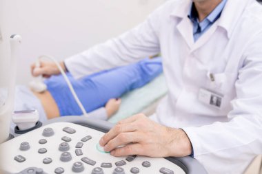 Hastanedeki hastanın muayenesi sırasında ultrason cihazları panelindeki çağdaş klinisyenlerin eli