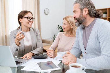 Genç, neşeli finansal danışman ya da temsilci olgun karı ve kocaya emekliler için olanaklar hakkında danışmanlık yapıyor.