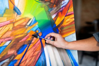 Özel enstrümanlı çağdaş ressamın eli soyut resim üzerinde çalışırken kağıt üzerinde renkleri karıştırıyor