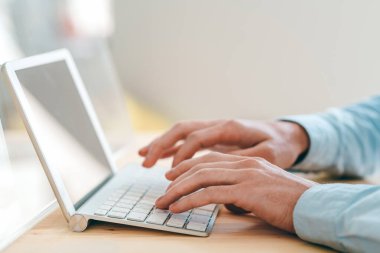 Genç web sitesi tasarımcısının elleri iş yerinde touchpad önünde çalışırken tuş takımına dokunuyor