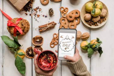 Noel indirimli akıllı telefonu elinde tutan kızın ellerine dikkatinizi çekerim.