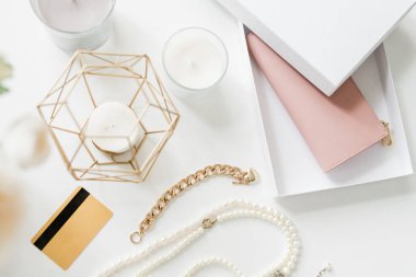 Bijou eşyalarının genel görünümü, plastik kart, bir grup mum ve masadaki yeni çıplak bej deri cüzdan.