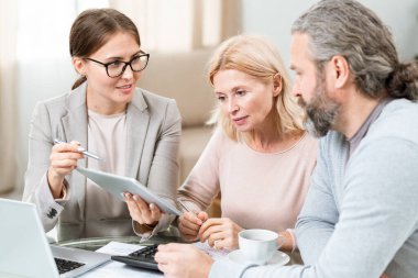 Güvenilir genç finansal danışman ya da sigorta acentesi dokunmatik belgeye işaret ediyor.