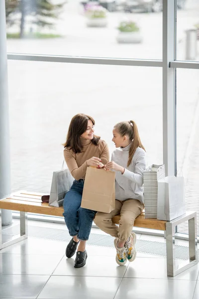 Chica Bonita Madre Sosteniendo Bolsa Papel Mientras Sienta Banco Discutir — Foto de Stock