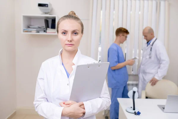 Jeune Femme Médecin Blonde Sérieuse Avec Document Debout Devant Caméra — Photo