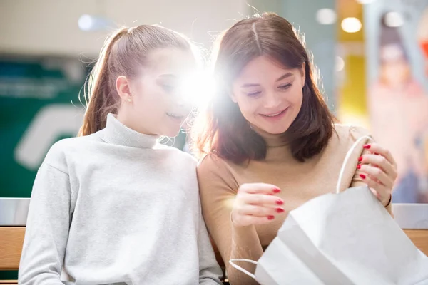 Young Female Holding Open Paperbag While Showing Cute Girl Gift — Stock Photo, Image