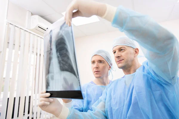 Médecins Jeunes Matures Uniforme Regardant Attentivement Radiographie Des Poumons Patient — Photo