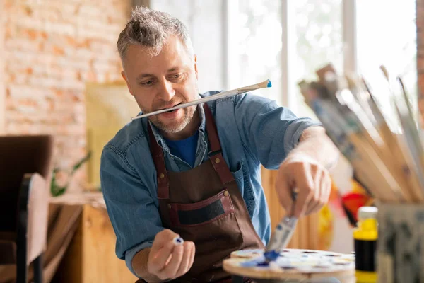 Pintor Contemporáneo Ropa Trabajo Sentado Mesa Taller Mientras Presiona Pintura —  Fotos de Stock