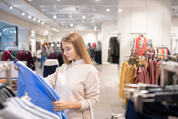 Söt Ung Kvinna Shoppare Står Vid Rack Med Nya Skjortor — Stockfoto