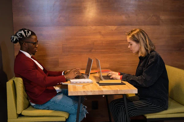 Dois Jovens Estudantes Ocupados Casualwear Sentado Mesa Café Enquanto Digita — Fotografia de Stock