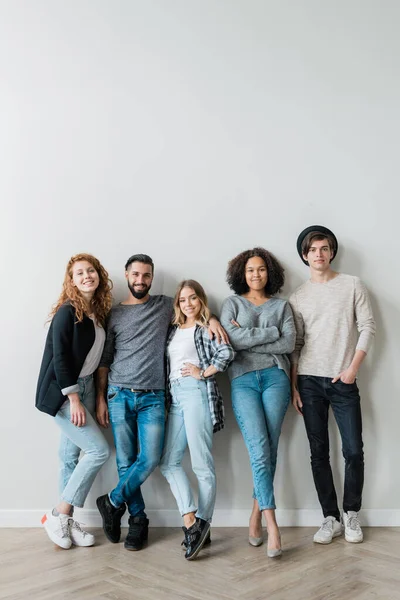 Grupo Alegres Jóvenes Amigos Cariñosos Jeans Pullovers Pie Junto Pared —  Fotos de Stock