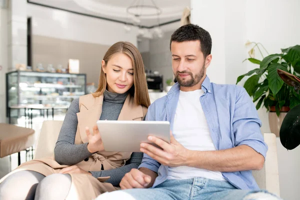 Lässiges Junges Paar Sitzt Auf Bequemer Couch Und Blättert Touchpad — Stockfoto