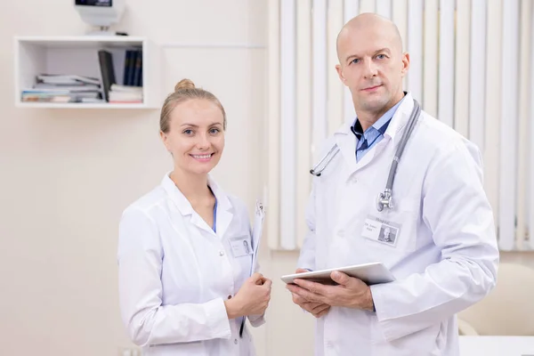 Jovem Feliz Clínico Bem Sucedido Seu Colega Sério Careca Whitecoats — Fotografia de Stock