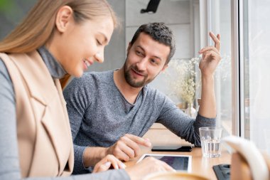 Mutlu genç çift internet dükkanında mal seçiyor ve kafede vakit geçirirken fiyatları tartışıyorlar.
