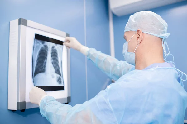有外科制服和面罩专业经验 观察肺部X光检查 对病人进行诊断 — 图库照片