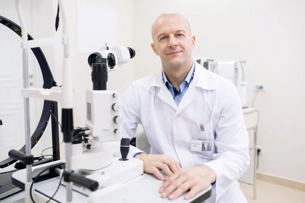 Feliz Oftalmologista Careca Meia Idade Whitecoat Sentado Por Local Trabalho — Fotografia de Stock