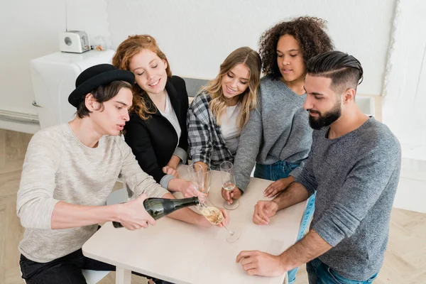 Joven Ropa Casual Sombrero Vertiendo Champán Botella Una Las Flautas — Foto de Stock