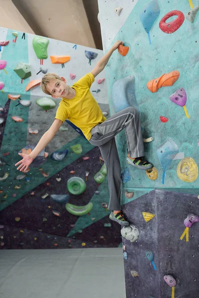 Aktif Kıyafetli Yakışıklı Bir Çocuk Tek Eliyle Duvara Tırmanıyor Kollarını — Stok fotoğraf