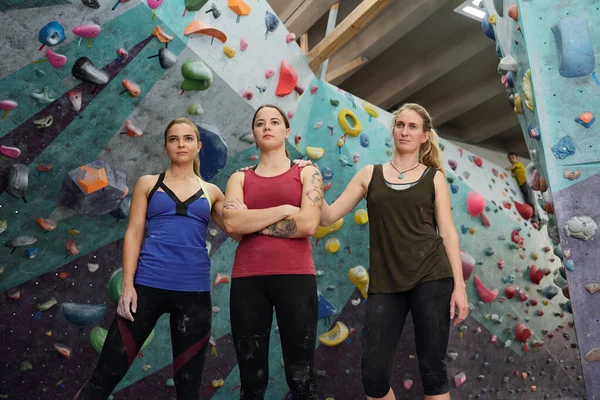 ジムでのハードトレーニングの後 クライミング機器に対して立っているスポーツウェアの3人の若いアクティブ女性 — ストック写真
