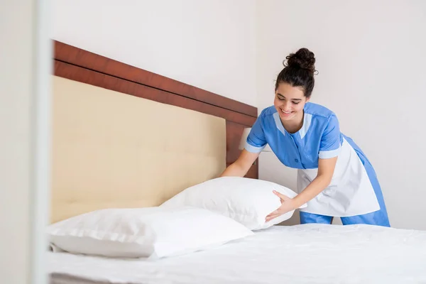 Menina Morena Feliz Uniforme Empregada Doméstica Colocando Almofadas Limpas Brancas — Fotografia de Stock