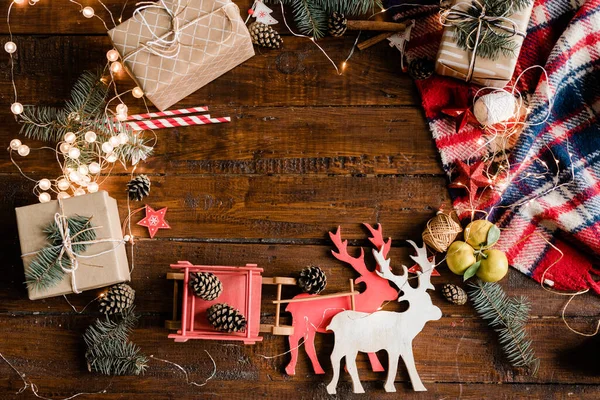 Kerst Achtergrond Met Speelgoed Herten Slee Geschenkdozen Dennenappels Naaldbomen Bloemenslingers — Stockfoto